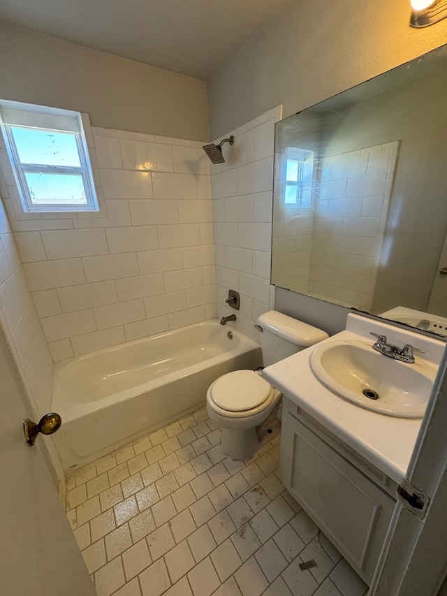 full bathroom featuring tiled shower / bath, vanity, and toilet