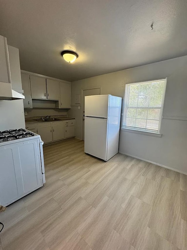 kitchen featuring sink, exhaust hood, a textured ceiling, white appliances, and white cabinets