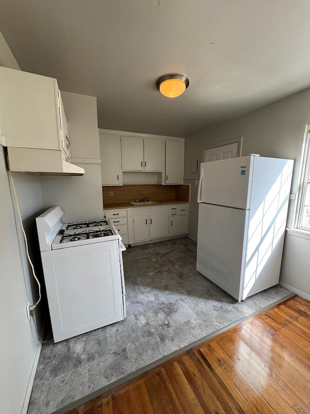 kitchen featuring white cabinetry, white appliances, wood-type flooring, and sink