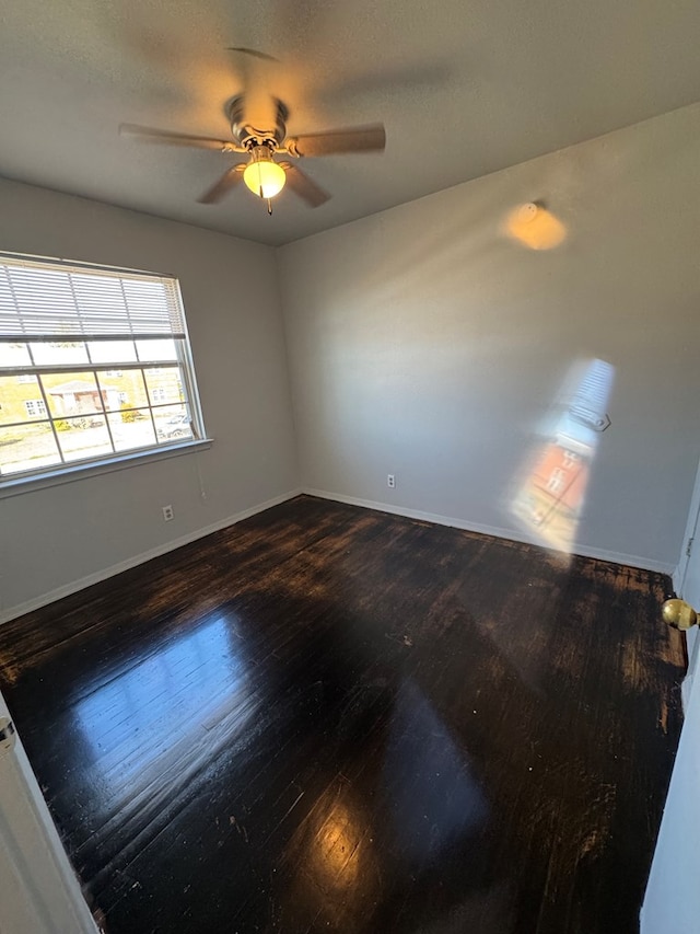 unfurnished room with dark wood-type flooring and ceiling fan