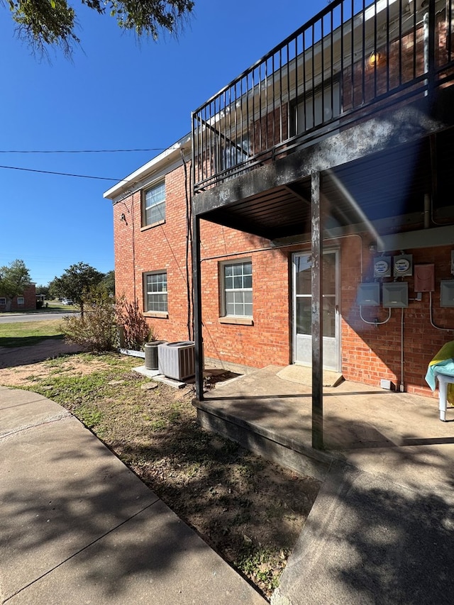 view of side of home with a patio and central AC unit