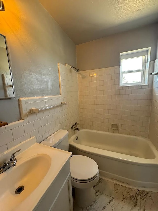 full bathroom featuring toilet, tasteful backsplash, tiled shower / bath, tile walls, and vanity