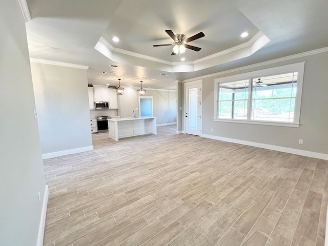 unfurnished living room with sink, ornamental molding, a raised ceiling, and ceiling fan