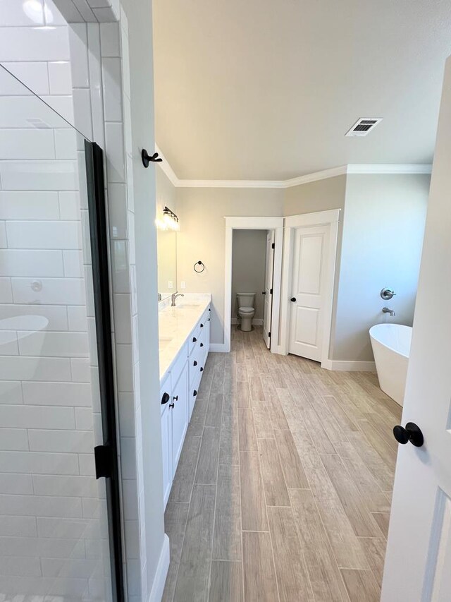 full bathroom featuring crown molding, separate shower and tub, vanity, and toilet