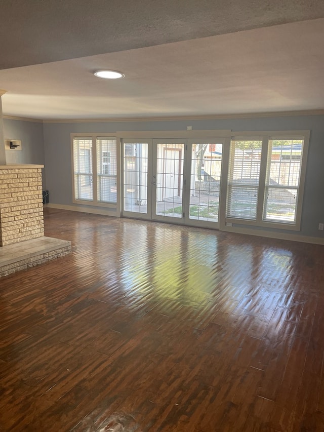 unfurnished living room with dark wood-type flooring and plenty of natural light