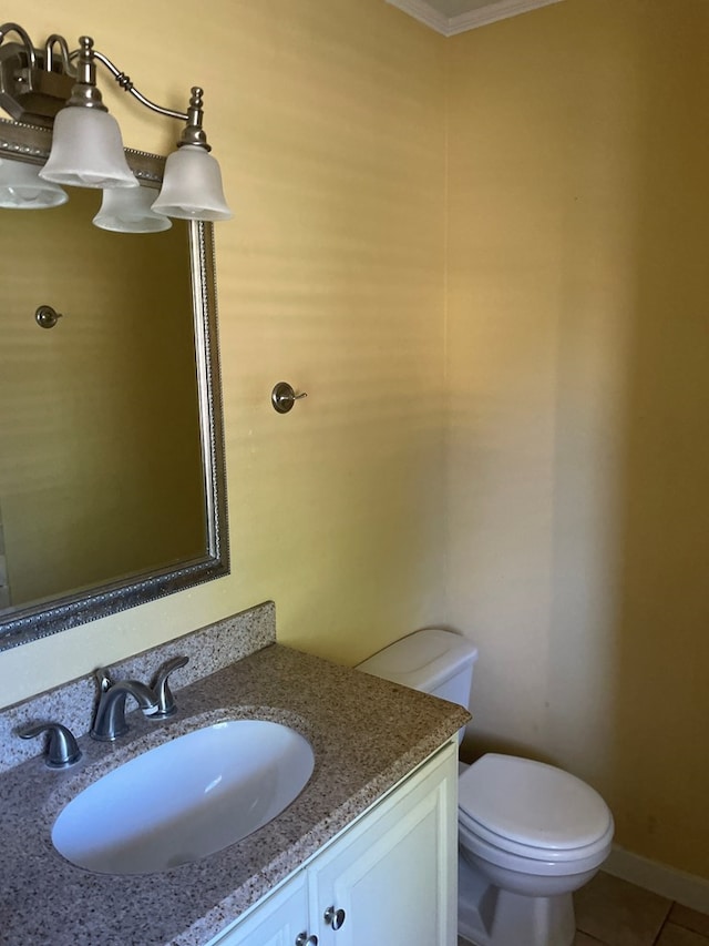 bathroom with tile patterned flooring, vanity, ornamental molding, and toilet