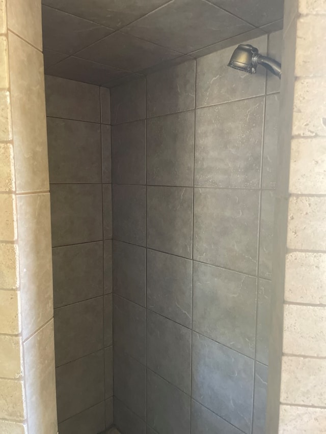 interior details with a tile shower