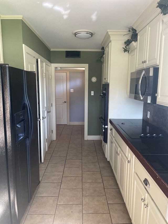 kitchen with crown molding, black fridge, light tile patterned floors, and double oven