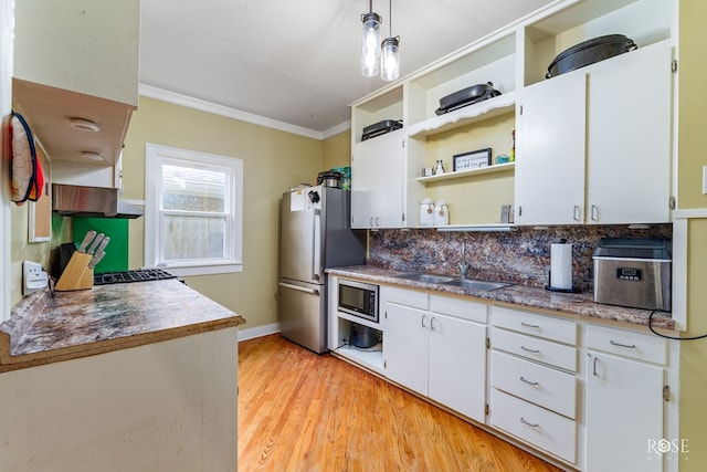 kitchen featuring sink, ornamental molding, stainless steel appliances, and white cabinets