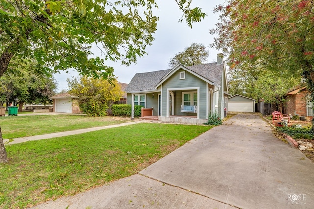 view of front of house with a garage, an outdoor structure, a front lawn, and covered porch