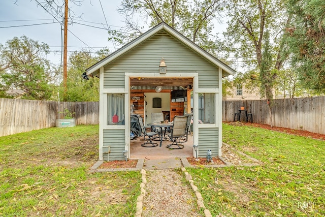 rear view of property featuring an outdoor structure and a yard