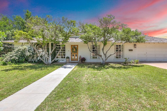 2121 Sul Ross St, San Angelo, TX 76904 - view of front of property with brick siding, an attached garage, a lawn, and french doors