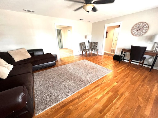 living room featuring wood-type flooring and ceiling fan