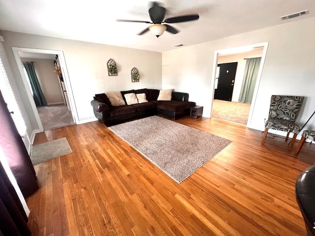 living room with ceiling fan and light hardwood / wood-style flooring