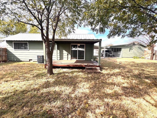 back of house featuring cooling unit, a deck, and a lawn