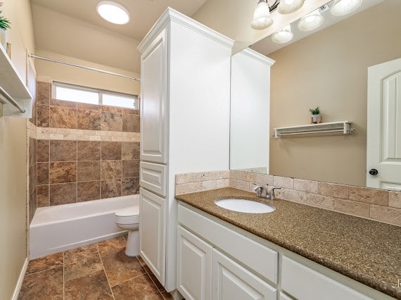 full bathroom featuring shower / tub combination, vanity, and toilet