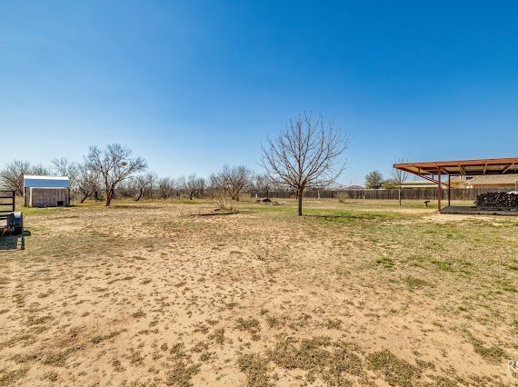 view of yard with fence and a rural view