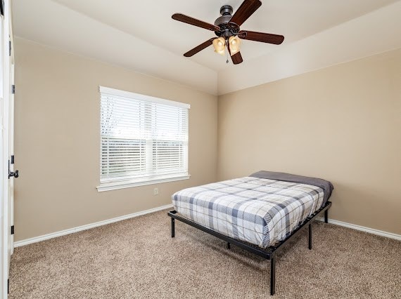 carpeted bedroom featuring ceiling fan, lofted ceiling, and baseboards