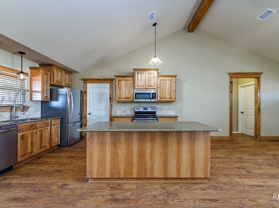 kitchen featuring visible vents, stainless steel appliances, dark wood-type flooring, and beamed ceiling