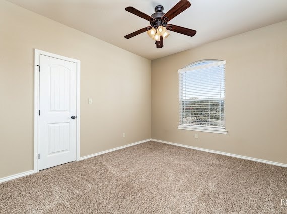 unfurnished room featuring carpet flooring, ceiling fan, and baseboards