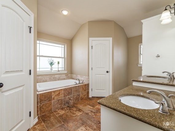 full bath featuring lofted ceiling, a sink, and a bath