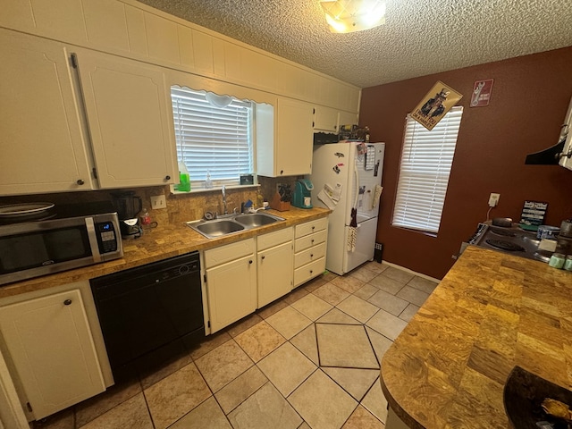 kitchen with white refrigerator, white cabinetry, dishwasher, and sink