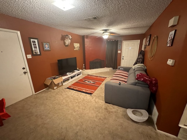 carpeted living room with ceiling fan and a textured ceiling