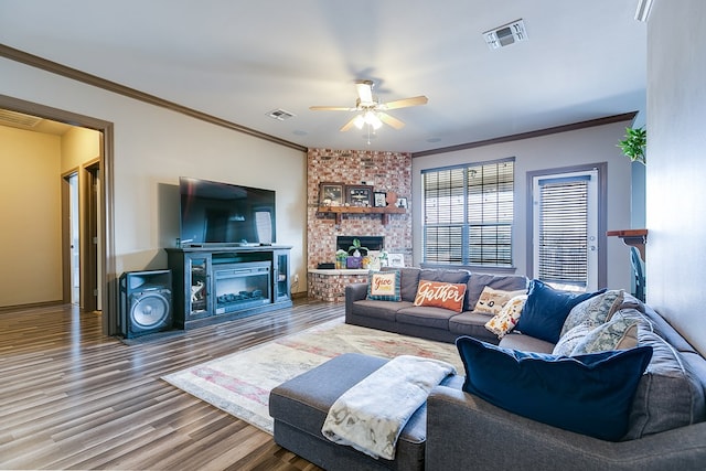 living area with a fireplace, wood finished floors, and visible vents