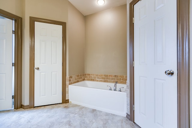 bathroom with tile patterned flooring and a bath