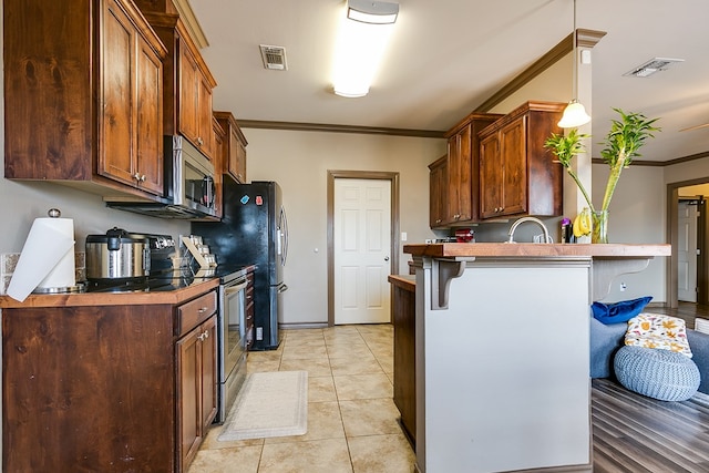 kitchen featuring a breakfast bar, crown molding, visible vents, appliances with stainless steel finishes, and a peninsula