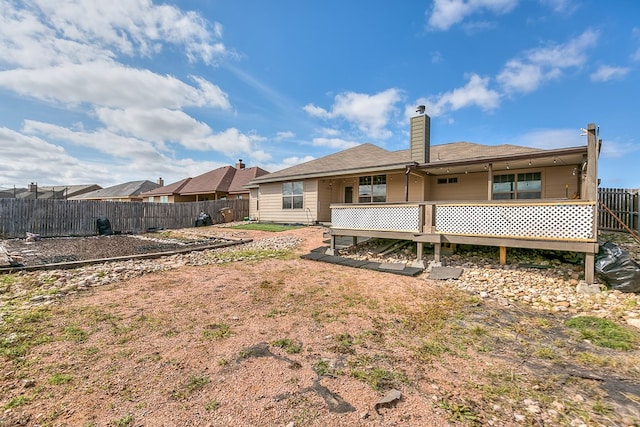 back of house featuring a fenced backyard and a chimney