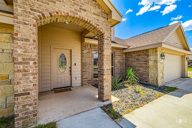 doorway to property featuring brick siding and a shingled roof