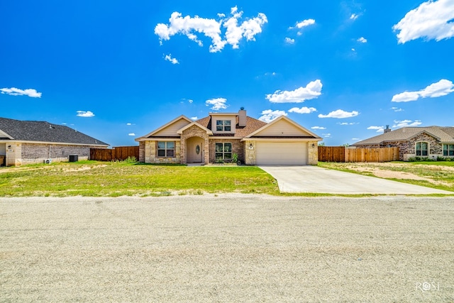 view of front facade with a garage, a front lawn, driveway, and fence