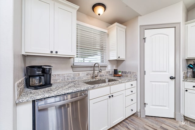 kitchen featuring a sink, light stone counters, white cabinetry, light wood finished floors, and dishwasher