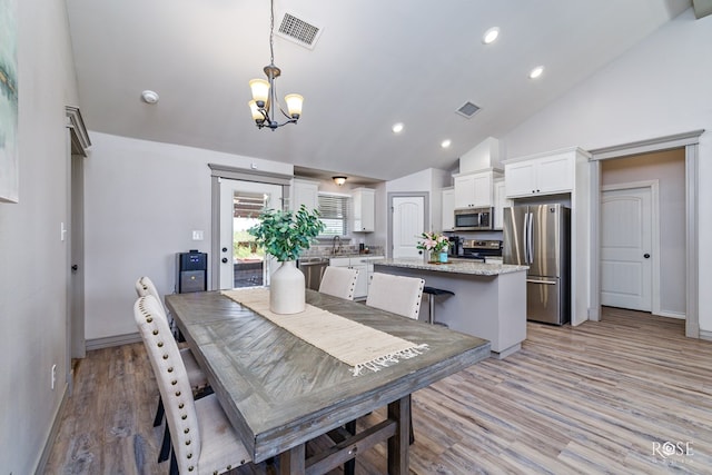 dining room featuring recessed lighting, visible vents, light wood-style floors, and a notable chandelier