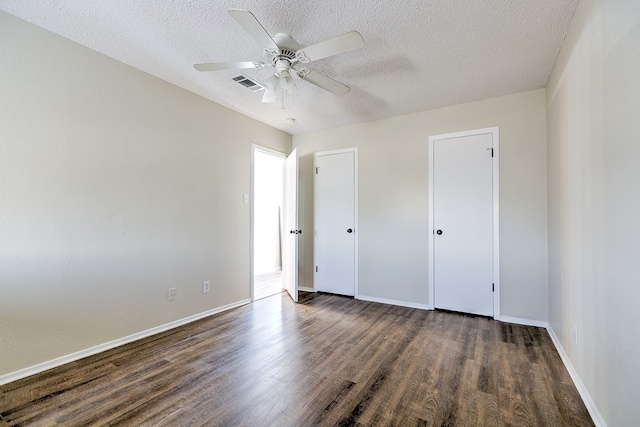 unfurnished bedroom with visible vents, baseboards, a ceiling fan, a textured ceiling, and dark wood-style floors