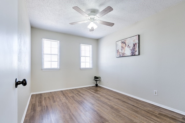 empty room with baseboards, a ceiling fan, wood finished floors, and a textured ceiling