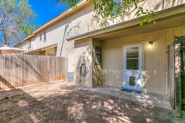 rear view of house with central AC and fence