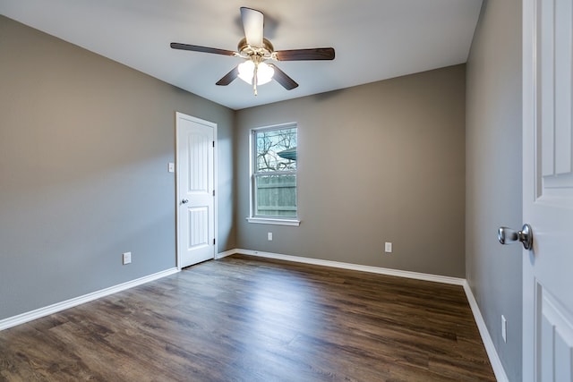 spare room featuring dark wood-type flooring and ceiling fan