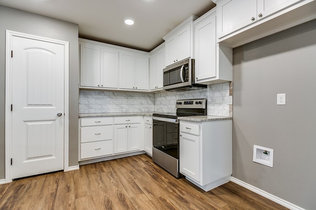 kitchen featuring appliances with stainless steel finishes, decorative backsplash, dark hardwood / wood-style flooring, and white cabinetry