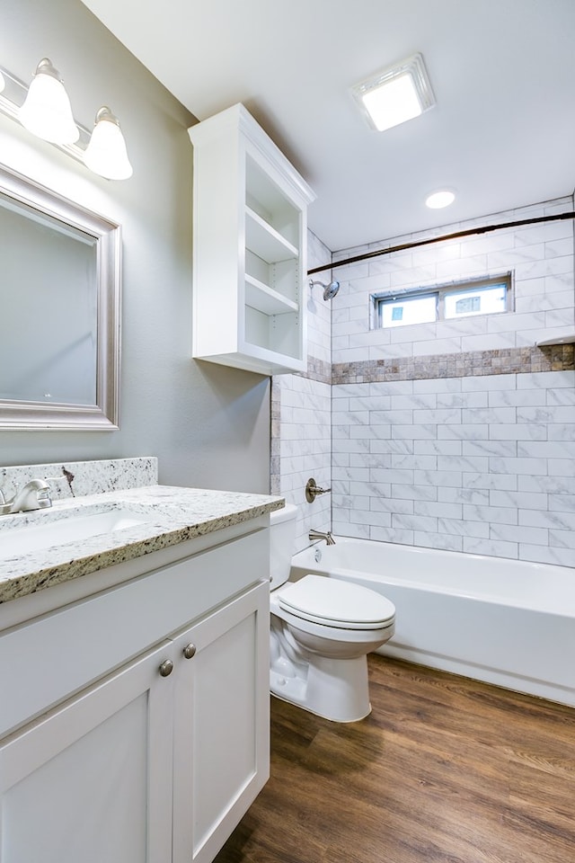 full bathroom with toilet, vanity, tiled shower / bath, and wood-type flooring