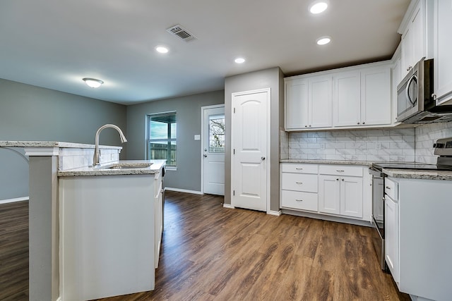 kitchen featuring white cabinetry, stainless steel appliances, a kitchen island with sink, and sink