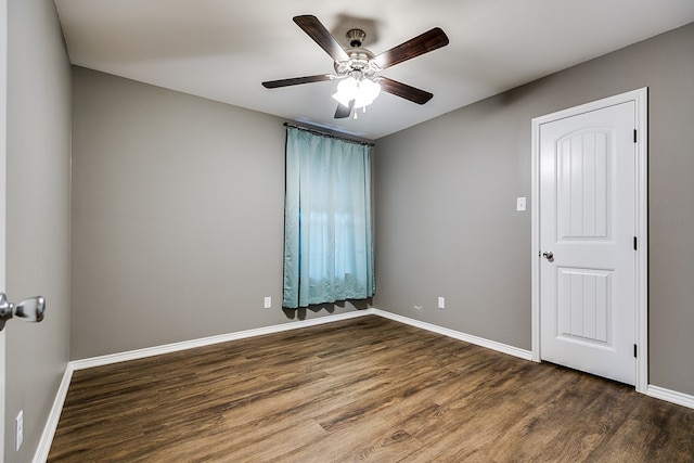 unfurnished room with ceiling fan and dark hardwood / wood-style flooring