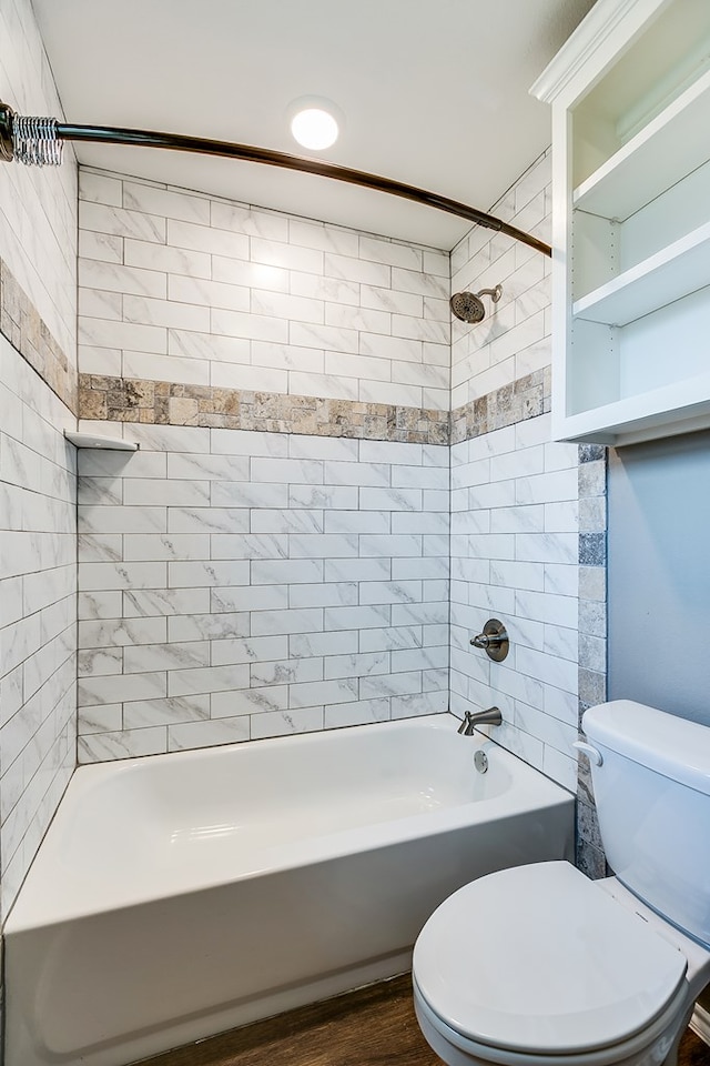 bathroom featuring tiled shower / bath combo, toilet, and hardwood / wood-style floors