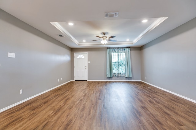 unfurnished room featuring hardwood / wood-style flooring, crown molding, ceiling fan, and a raised ceiling