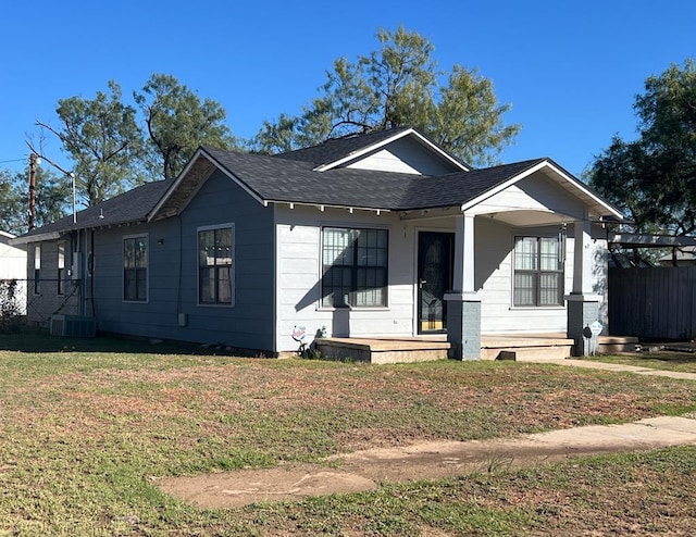 bungalow-style house with a porch, a front yard, and a shingled roof