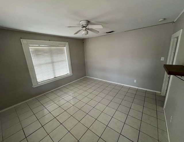 unfurnished room with baseboards, visible vents, and a ceiling fan