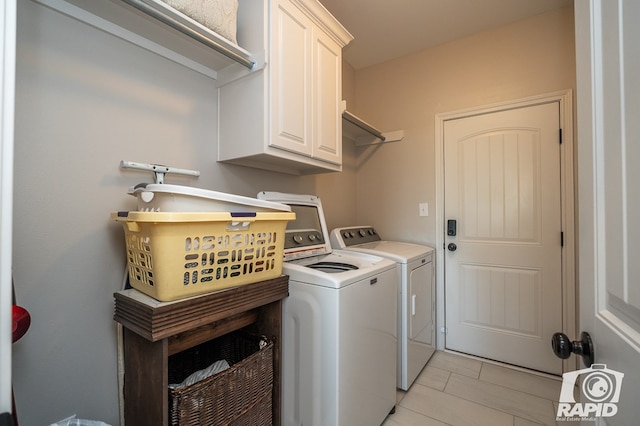 laundry area featuring cabinets, washer and dryer, and light tile patterned floors