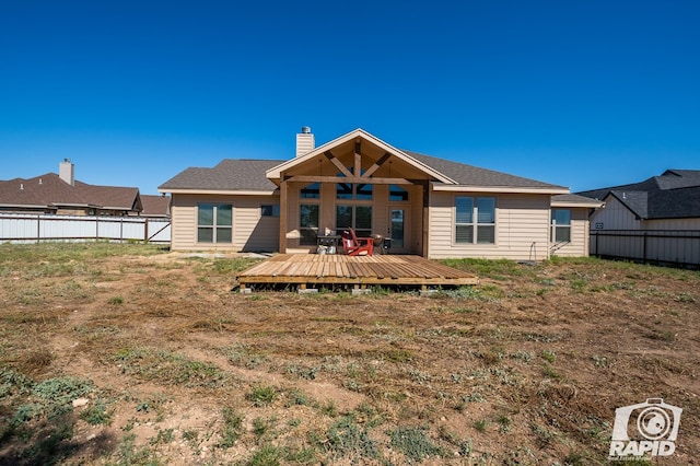 rear view of house with a yard and a deck