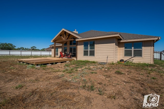 rear view of property featuring a wooden deck